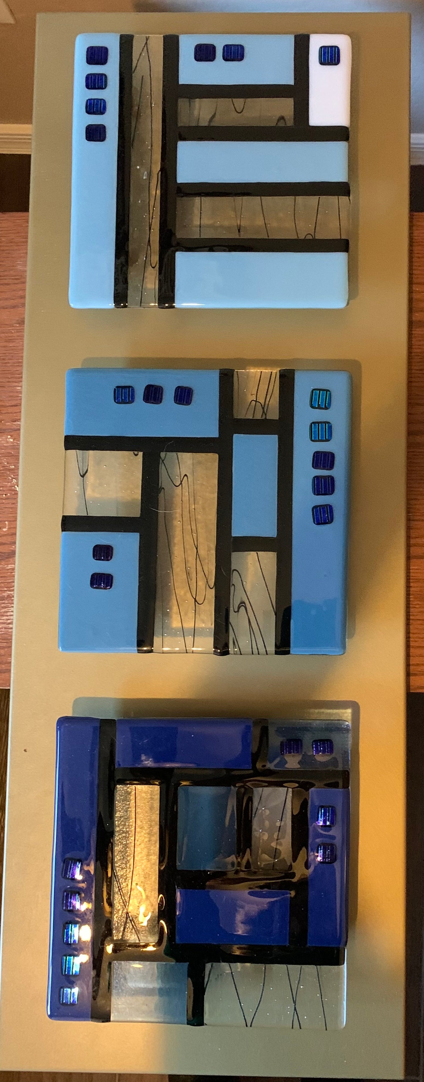 Triad of glass in blues on gold frame