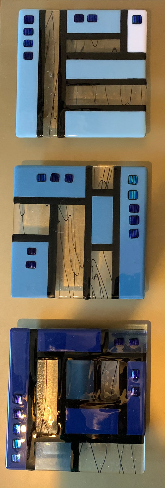 Triad of glass in blues on gold frame